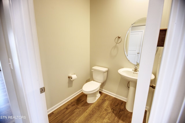 bathroom with toilet and hardwood / wood-style floors