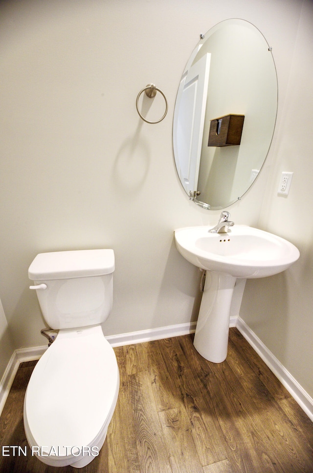 bathroom featuring wood-type flooring and toilet