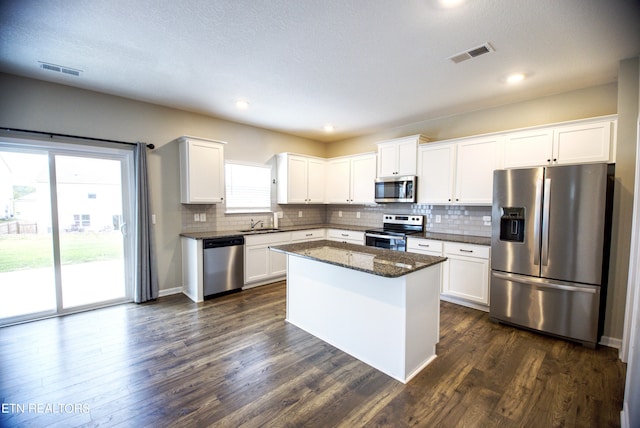 kitchen with white cabinetry, stainless steel appliances, and a wealth of natural light