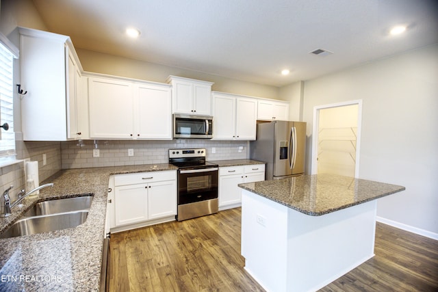 kitchen featuring stone countertops, stainless steel appliances, sink, and white cabinetry