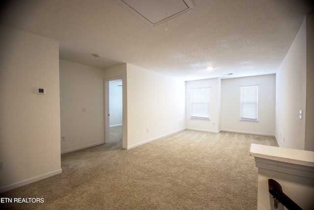 carpeted spare room featuring a textured ceiling