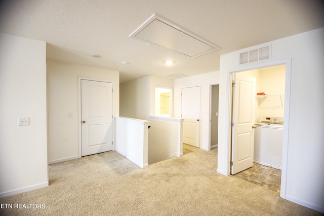 spare room featuring light carpet and washer / clothes dryer