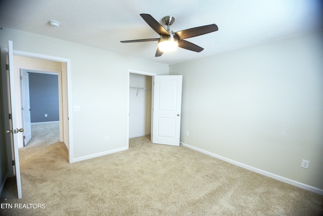 unfurnished bedroom with ceiling fan, a closet, and light carpet