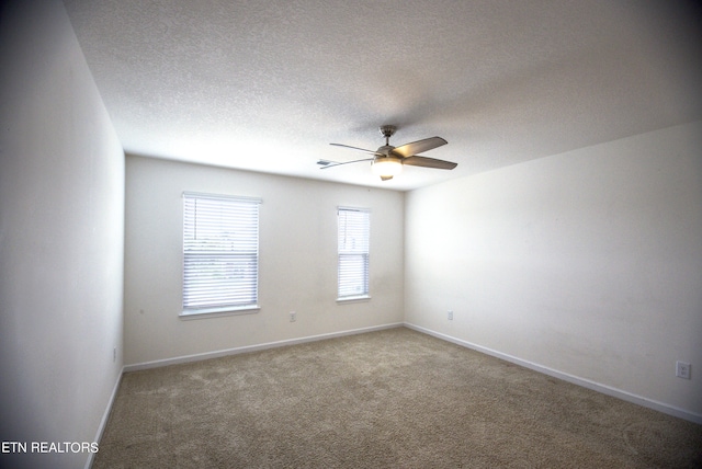 empty room featuring ceiling fan, carpet floors, and a textured ceiling