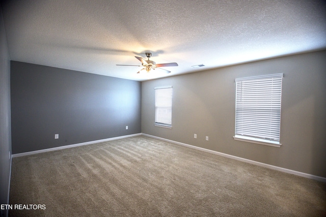 carpeted empty room featuring ceiling fan and a textured ceiling