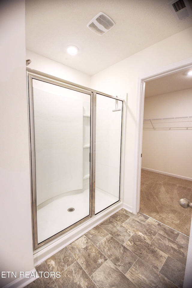 bathroom with a shower with door