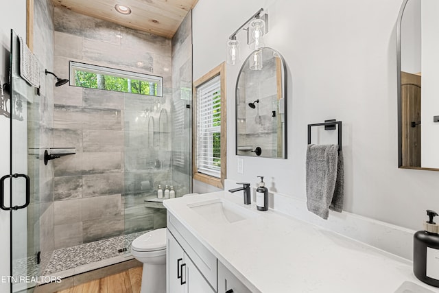 bathroom featuring vanity, hardwood / wood-style floors, toilet, and an enclosed shower