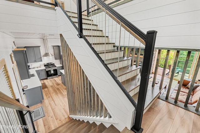 stairs featuring wooden walls and hardwood / wood-style floors