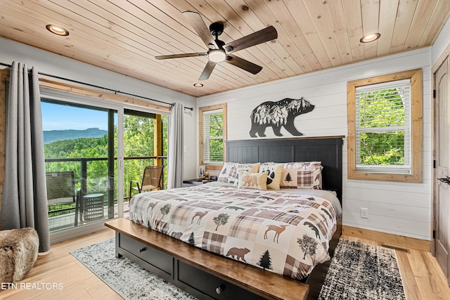 bedroom with wood ceiling, light hardwood / wood-style floors, wood walls, ceiling fan, and access to outside