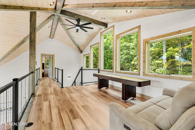 interior space with ceiling fan, wood ceiling, wood walls, light hardwood / wood-style flooring, and lofted ceiling with beams