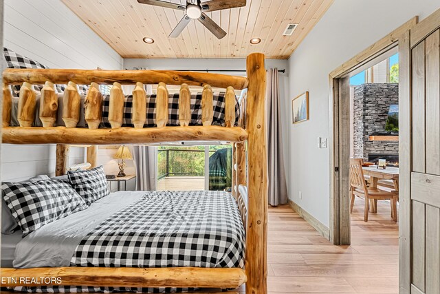 bedroom featuring multiple windows, light hardwood / wood-style flooring, and wooden ceiling