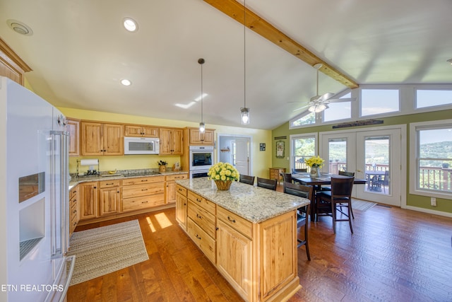 kitchen with a center island, a kitchen breakfast bar, vaulted ceiling with beams, white appliances, and ceiling fan