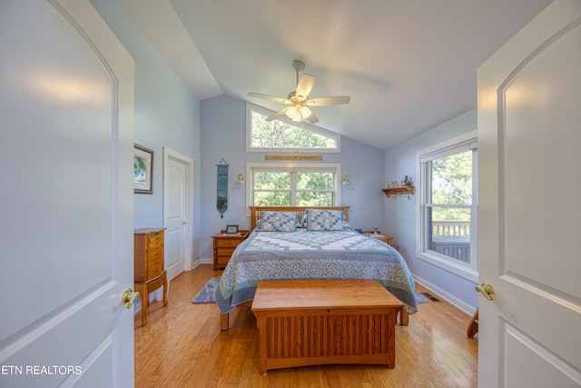 bedroom featuring light hardwood / wood-style floors, multiple windows, vaulted ceiling, and ceiling fan