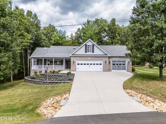 view of front of house with a front yard, a garage, and a porch