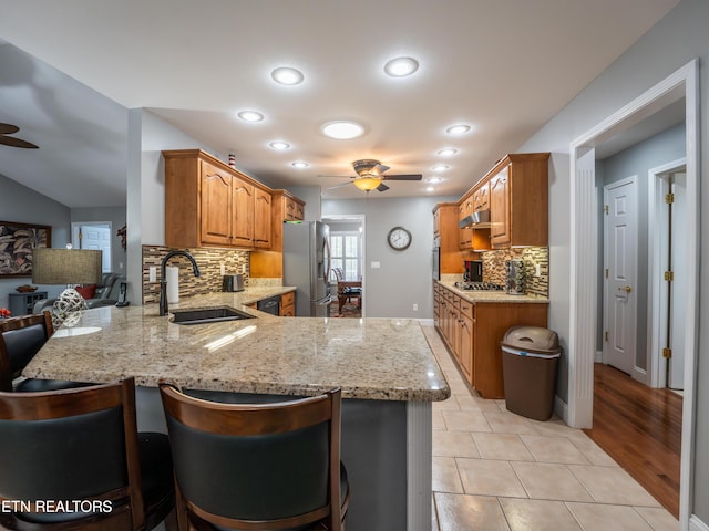 kitchen featuring sink, kitchen peninsula, light hardwood / wood-style flooring, appliances with stainless steel finishes, and ceiling fan