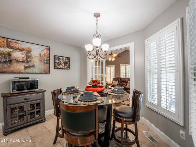 tiled dining space featuring a notable chandelier