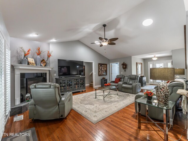 living room with wood-type flooring, lofted ceiling, and ceiling fan