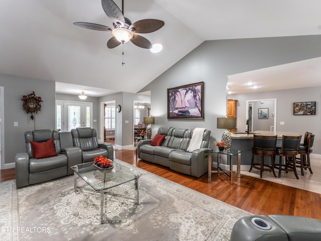 living room with lofted ceiling, hardwood / wood-style floors, and ceiling fan