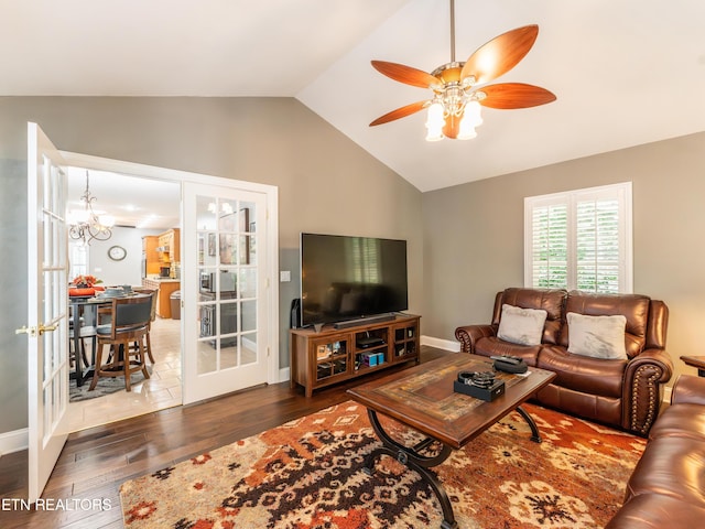 living room featuring ceiling fan with notable chandelier, vaulted ceiling, and dark hardwood / wood-style flooring