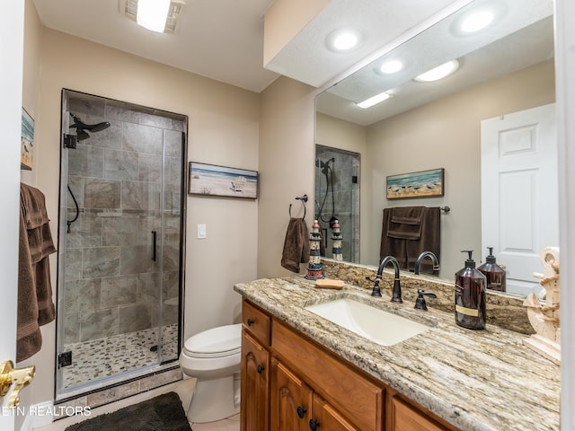 bathroom with vanity, a shower with shower door, toilet, and tile patterned floors