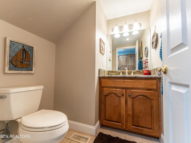 bathroom with vanity, toilet, vaulted ceiling, and tile patterned floors