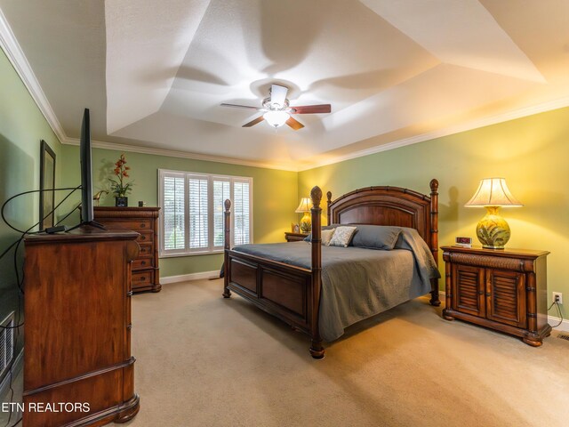 carpeted bedroom featuring crown molding, a tray ceiling, and ceiling fan