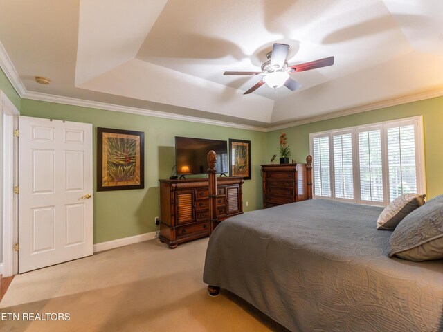 carpeted bedroom featuring ceiling fan, a raised ceiling, and crown molding