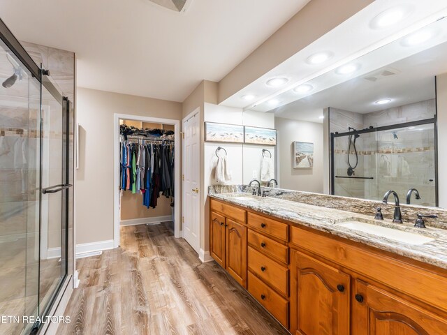 bathroom featuring wood-type flooring, walk in shower, and vanity