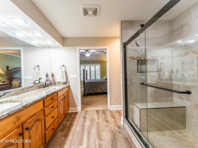 bathroom featuring ceiling fan, vanity, hardwood / wood-style floors, and an enclosed shower