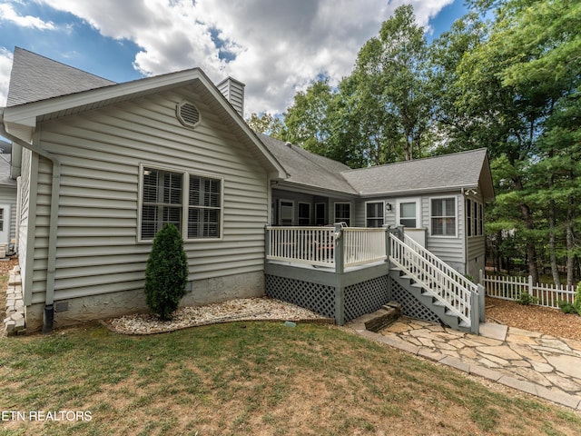 rear view of house with a lawn and a deck