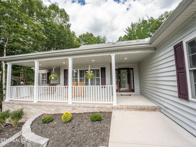 view of exterior entry featuring covered porch