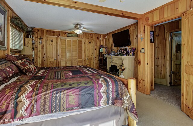 carpeted bedroom featuring wood walls and ceiling fan