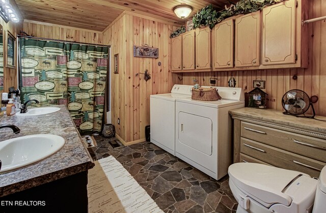 interior space featuring wood ceiling, wooden walls, and washing machine and clothes dryer