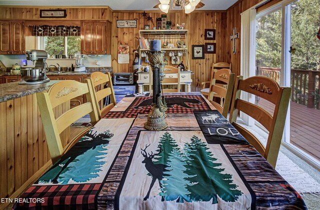 dining room featuring ceiling fan and wood walls