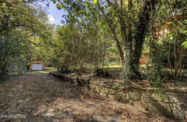 view of yard featuring a garage and an outdoor structure