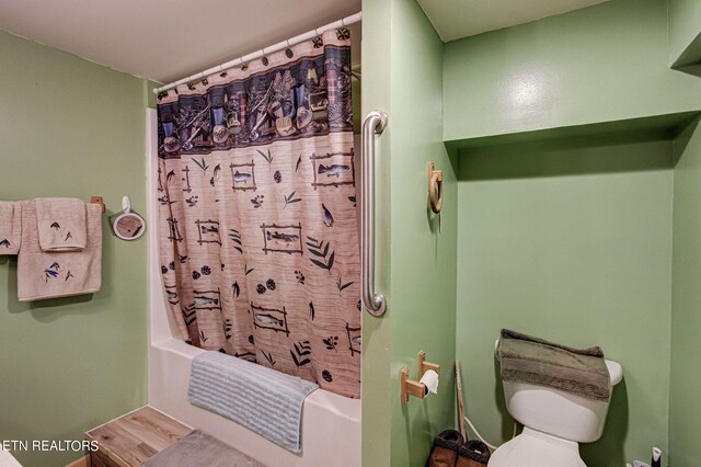 bathroom featuring shower / tub combo and toilet