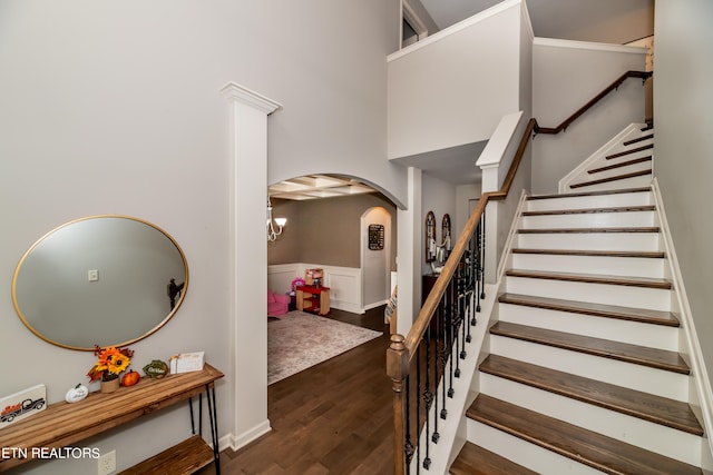 stairway featuring a notable chandelier, a towering ceiling, and hardwood / wood-style flooring