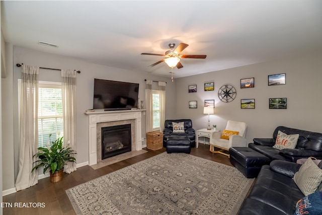 living room featuring ceiling fan, a tile fireplace, and dark hardwood / wood-style flooring