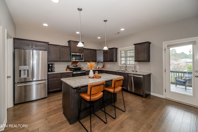 kitchen featuring a kitchen island, stainless steel appliances, sink, and a wealth of natural light