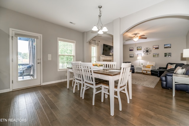 dining room featuring ceiling fan with notable chandelier and dark hardwood / wood-style floors