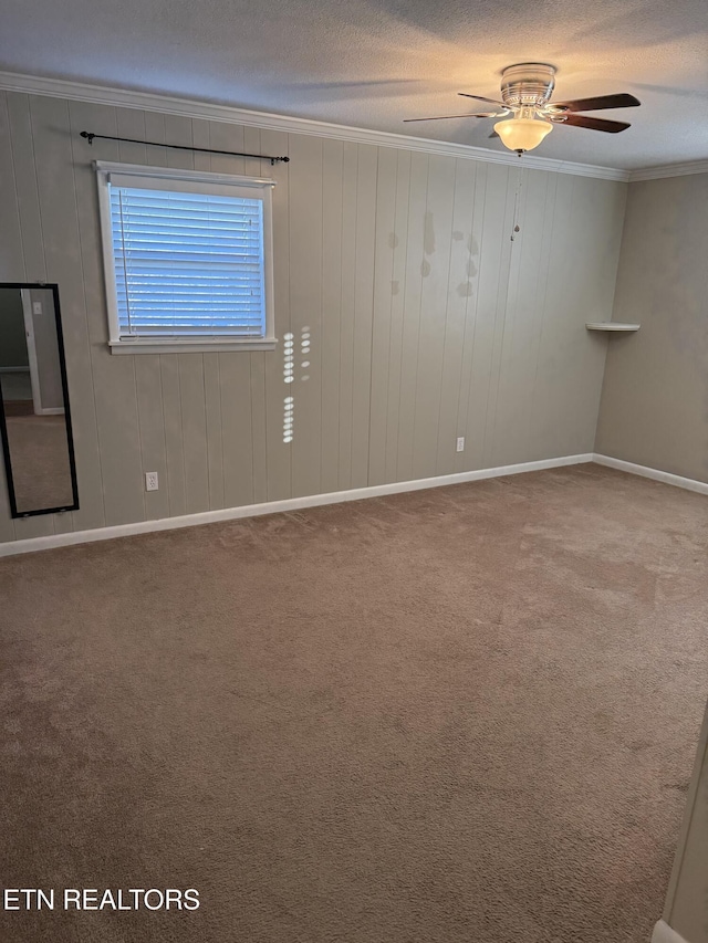 spare room featuring crown molding, ceiling fan, carpet floors, and a textured ceiling