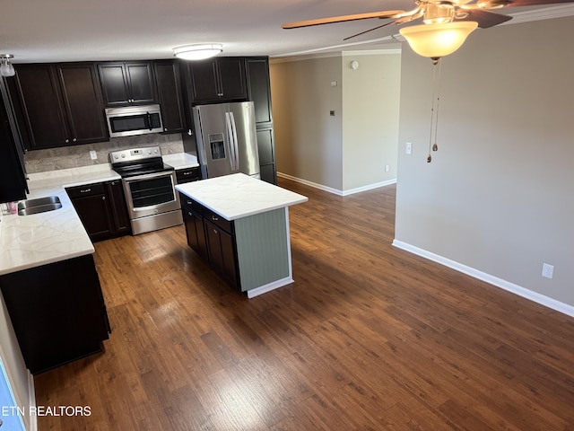 kitchen with sink, decorative backsplash, hardwood / wood-style flooring, a center island, and stainless steel appliances