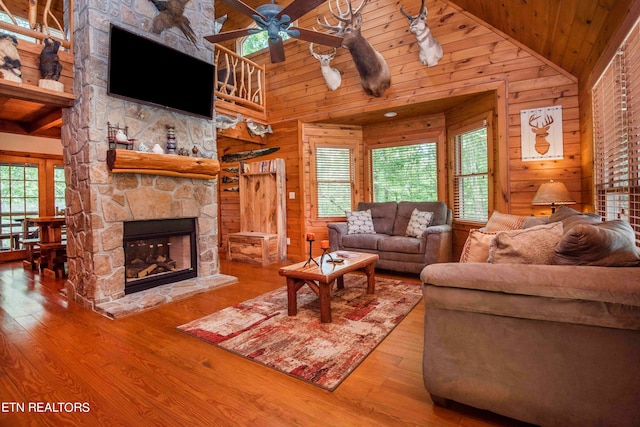 living room featuring high vaulted ceiling, ceiling fan, a fireplace, and a healthy amount of sunlight