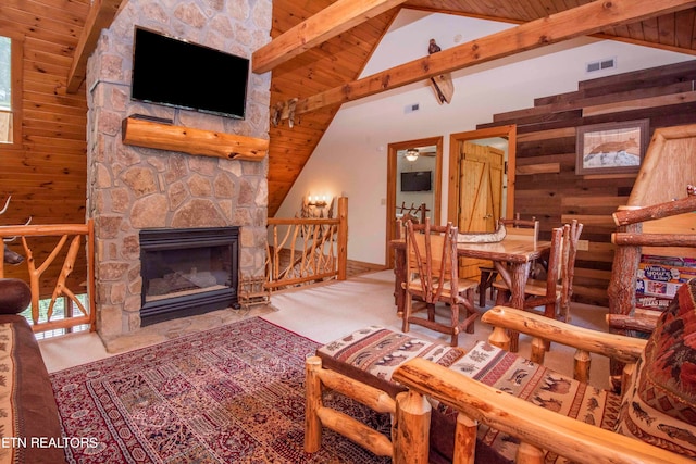 living room featuring ceiling fan, beamed ceiling, a fireplace, and wood ceiling