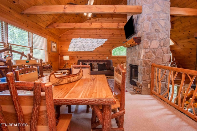 dining space with a wealth of natural light, wooden ceiling, a fireplace, and wooden walls