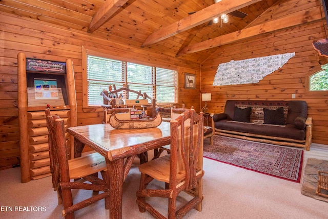 carpeted dining area featuring ceiling fan, vaulted ceiling with beams, wood ceiling, and wood walls