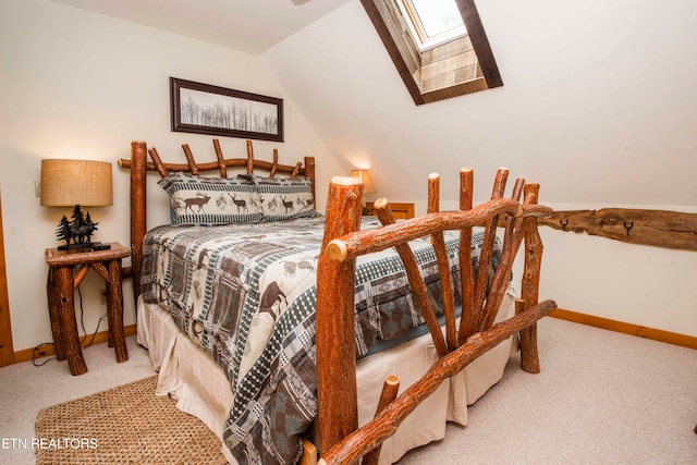 carpeted bedroom with vaulted ceiling with skylight