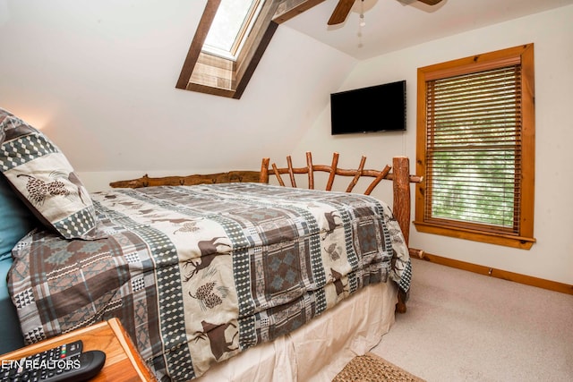 carpeted bedroom with ceiling fan and lofted ceiling with skylight