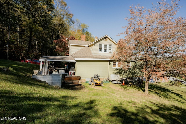 rear view of property featuring a yard