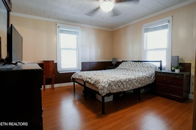 bedroom featuring wood-type flooring, ceiling fan, and ornamental molding